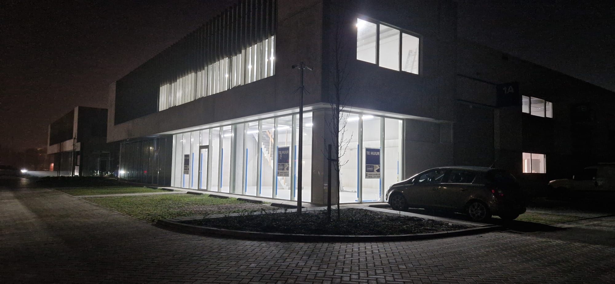 Nachtfoto van bedrijfspand stralend helder verlicht